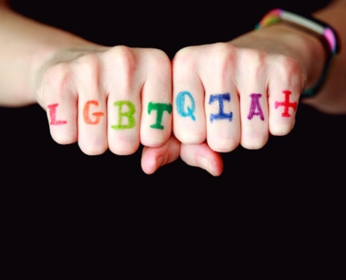 Painted knuckles spelling LGBTQIA+