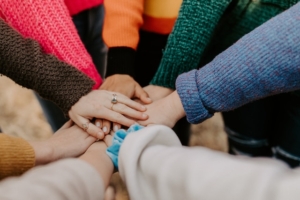 A circle of people putting their hands together in unity